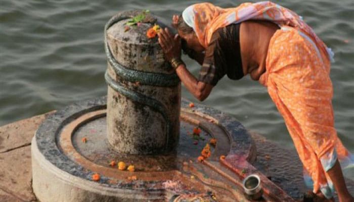 Creyente adorando al Shiva Lingam